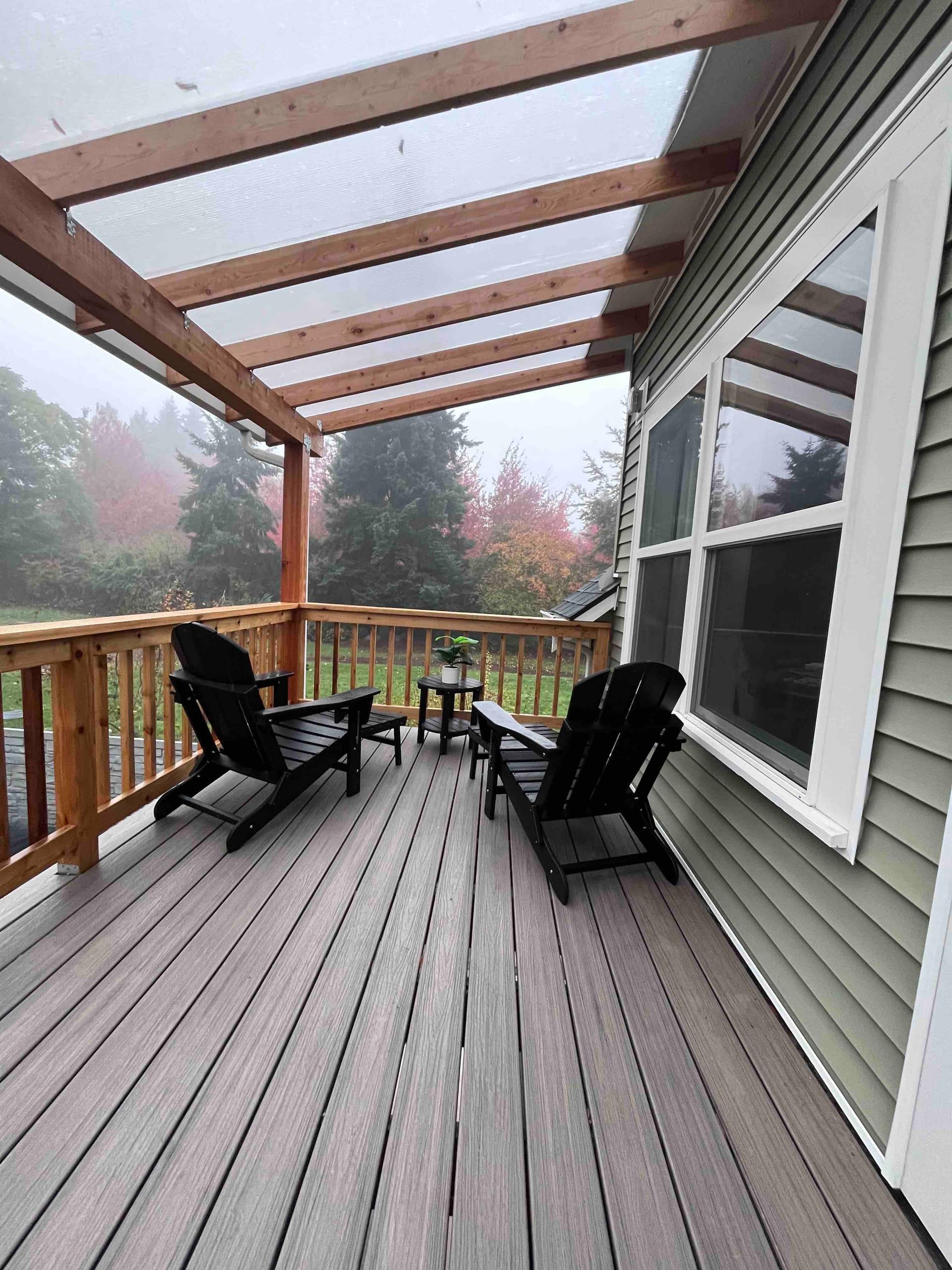 Adirondack chairs on the deck overlooking the green backyard