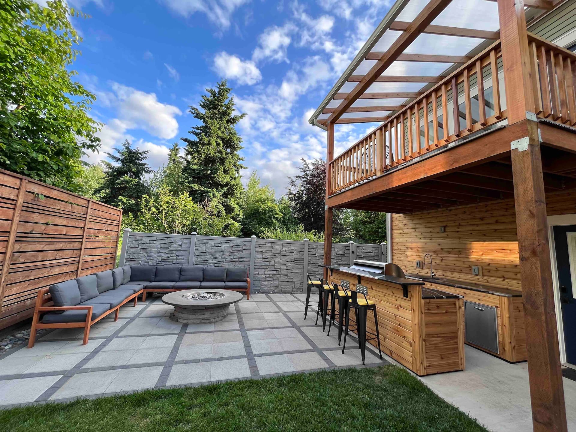 The back deck at dusk — swim spa, lounge seating, and warm string lights